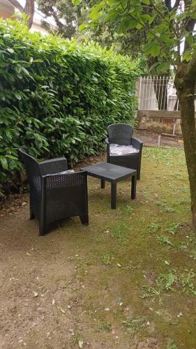three black chairs and a table in a yard at Villa Giove Rooms in Prato