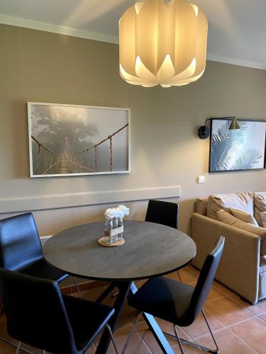 une salle à manger avec une table, des chaises et un canapé dans l'établissement Élégant appartement sur le Golf de Pont Royal, à Mallemort