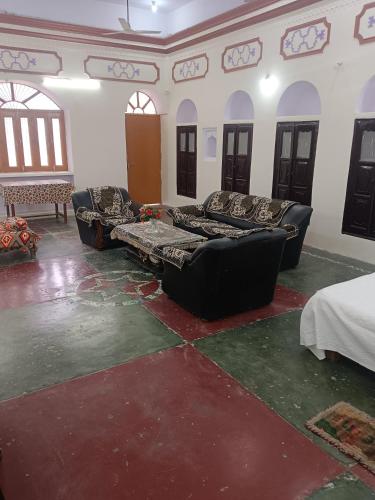 a living room with couches and a table and windows at Topper stay in Varanasi