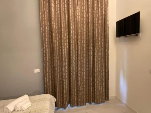 a curtain in a room with a couch and a television at Villa Giove Rooms in Prato