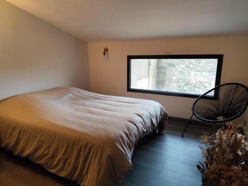 une chambre avec un lit, une fenêtre et une chaise dans l'établissement Sur la Terrasse, à Sigean