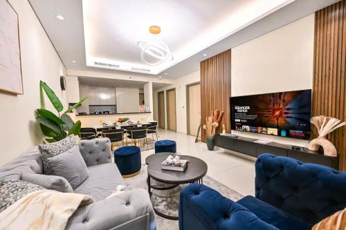 a living room with a couch and a tv at New Luxury 2 Bedroom with Burj Khalifa View & Spectacular Rooftop Infinity Pool Bar in Dubai