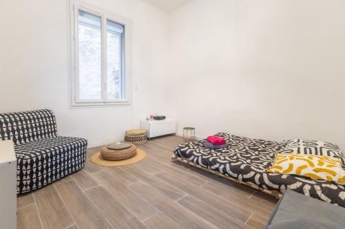 un salon avec un lit et une chaise dans l'établissement Notre Dame & Mer, à Marseille