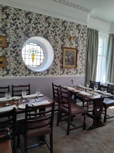a dining room with tables and chairs and a window at Tower Hotel in Oxton