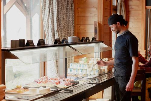 a man is preparing food in a restaurant kitchen at Hôtel Le Montana in La Tania