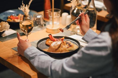 a person sitting at a table with a plate of food at Hôtel Le Montana in La Tania