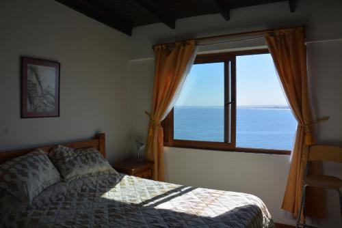 a bedroom with a bed and a large window at Con Con Bay in Concón