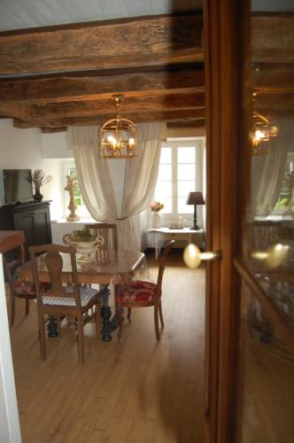 une salle à manger avec une table, des chaises et un lustre dans l'établissement 7 Au Charme d'Antan, à Beaumont-du-Périgord