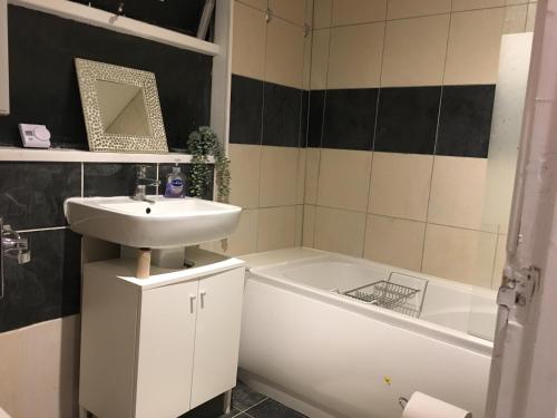 a bathroom with a sink and a bath tub and a sink at 2 bed flat Centre Swansea in Swansea