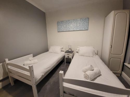 two beds in a small room with towels on them at 2 bed flat Centre Swansea in Swansea