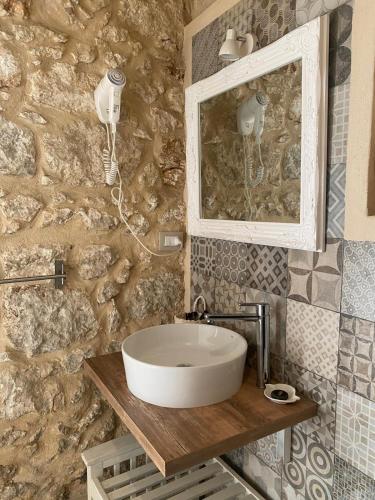 a bathroom with a sink and a stone wall at Corte Sicula in Syracuse
