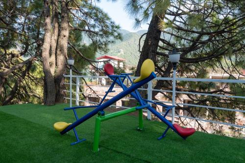 a playground with a slide in the grass at DLS Nature Trinket Resort - Dalhousie with Swimming Pool in Dalhousie