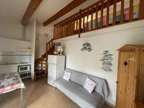 un salon avec un canapé et une cuisine dans l'établissement Maison de vacances dans résidence MARINES avec piscine commune, 4 couchages, 250 m de la mer à PORTIRAGNES Plage LRMA4, à Portiragnes