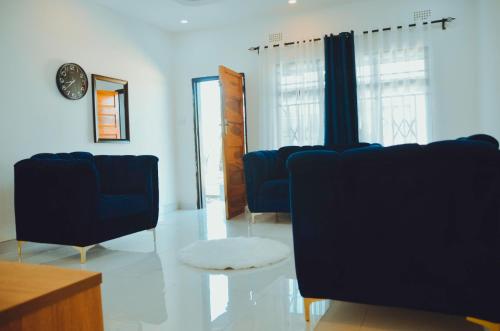 a living room with blue chairs and a table at Smooth apartments and tours in Livingstone