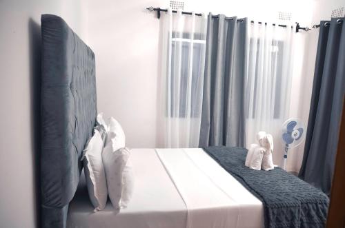 a bedroom with a bed with two stuffed animals on it at Smooth apartments and tours in Livingstone