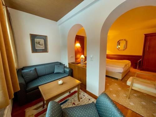 a living room with a couch and a bed at Hotel Garni Zerzer in Serfaus