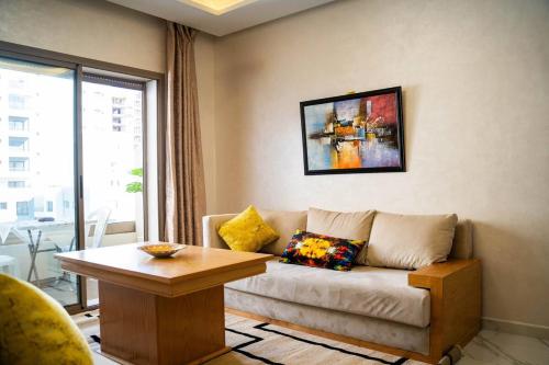 a living room with a couch and a table at Charmante Deux Chambres et Salon Avec Jardin et Piscine à coté de plage in Casablanca