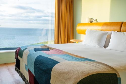 a bedroom with a bed with a view of the ocean at SeaSpace in Newquay