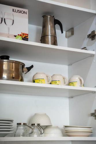 a shelf with cups and dishes in a kitchen at Charmante Deux Chambres et Salon Avec Jardin et Piscine à coté de plage in Casablanca
