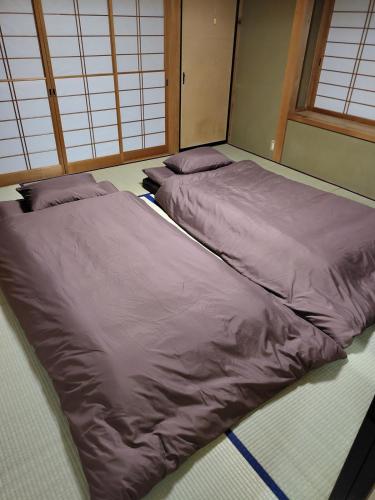 two beds sitting on the floor in a room at はなおか in Takayama