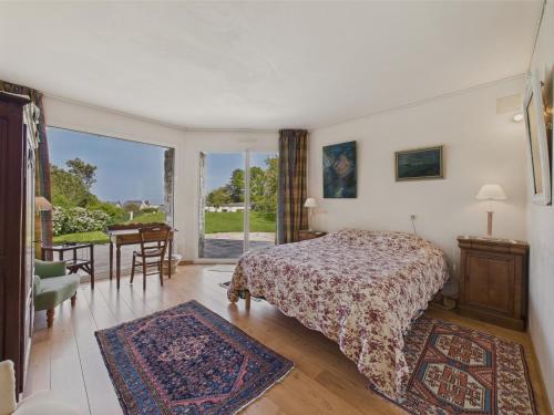 une chambre avec un lit, une table et une fenêtre dans l'établissement Vue mer - Grande maison pour 7 adultes et 1 enfant, à Trévou-Tréguignec