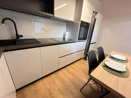 a kitchen with a wooden table and a table and chairs at Villa Naledi in Pašman