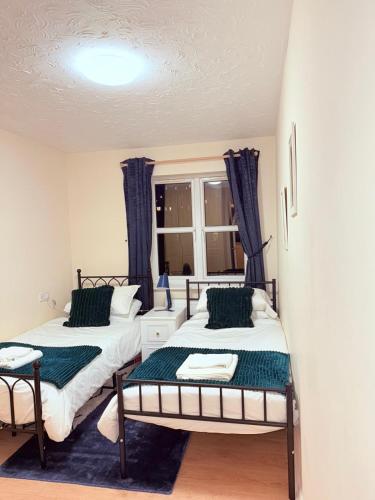 a bedroom with two beds and a window at Central Comfort Southampton, Free Parking in Southampton