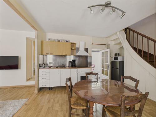 une cuisine avec une table en bois et une salle à manger dans l'établissement Plein centre ville - maison pour 4 avec terrasse, à Sarlat-la-Canéda