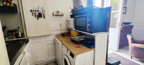 une cuisine avec un comptoir avec un gros électroménager bleu dans l'établissement ATYPIQUE T2 de 35 m avec JARDIN proche de la MER, à Arcachon