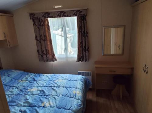 une chambre avec un lit et une fenêtre dans l'établissement Mobil 6 Places direct sur la plage, à Camiers