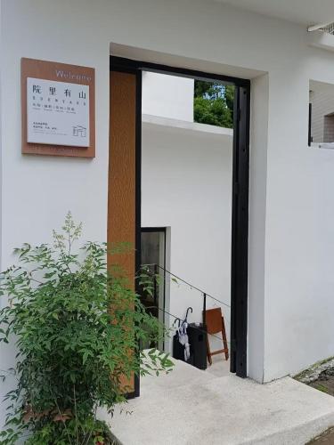 a door to a building with a clock on the wall at Eden Yard Boutique Hotel and Experiences in Xianghu