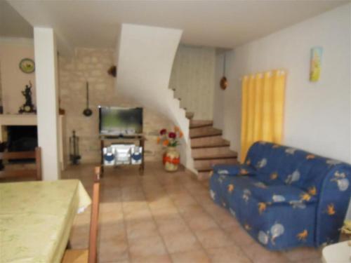 - un salon avec un canapé bleu et un escalier dans l'établissement villa MI RE LA, à Saint-Denis-dʼOléron