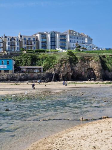 a group of people walking on the beach at Dune Breeze-Haven Perran Sands Holiday Park in Perranporth