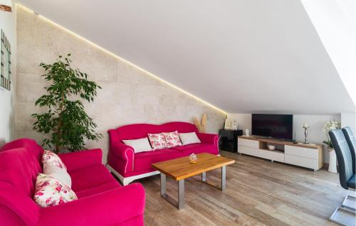 un salon avec deux canapés rouges et une table dans l'établissement 2 Bedroom Lovely Apartment In Hvar, à Hvar