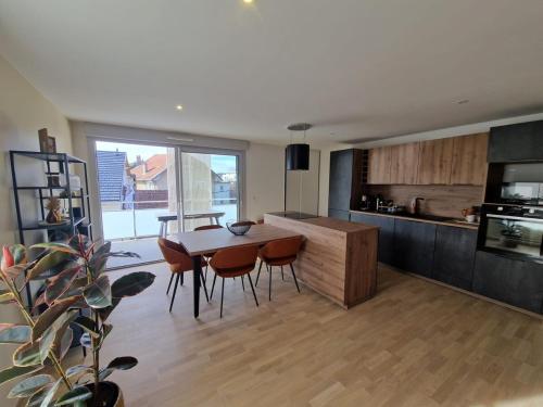 une cuisine avec une table et des chaises dans une pièce dans l'établissement T3 spacieux, proche du lac et du grand port avec garage, à Aix-les-Bains