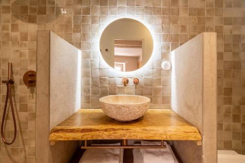 une salle de bain avec un lavabo et un miroir dans l'établissement La Genive Arles Roquette, à Arles