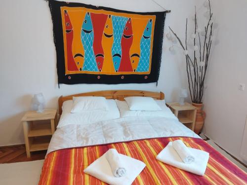 a bedroom with a bed with two towels on it at Keszi Széli Vendégház in Gyulakeszi
