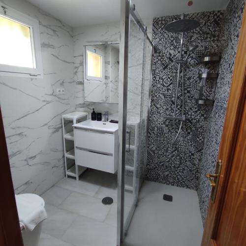 a white bathroom with a shower and a sink at Paraíso del mar- Villa privada con piscina propia y vista al mar cerca de la playa in Fuengirola