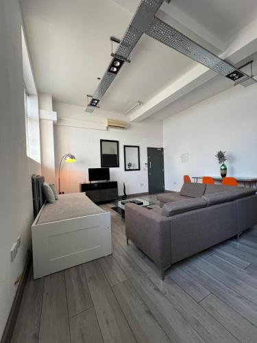 a living room with a couch and a table at Modern 2bed warehouse conversion apartment for 6 people - London in London