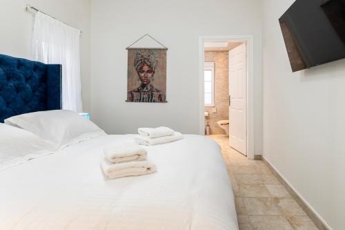 a bedroom with a white bed with towels on it at Villa Irene Royale - Pool - Sea View - Free Cruise in Tigaki