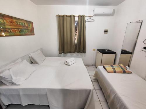 a bedroom with two beds and a window in it at Pousada Tiriri Guesthouse in Barra do Camaragibe