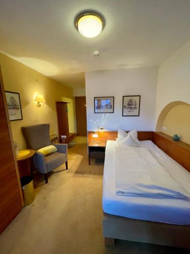 a hotel room with a bed and a chair at Hotel Garni Zerzer in Serfaus
