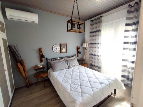 a bedroom with a white bed and a clock on the wall at Casa Katina , villa in Lagana, Agrilia area in Laganas