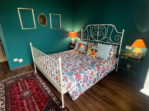 una camera da letto con un letto e una parete verde di LA MAGIA nel BORGO a Fezzano