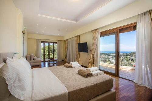 a bedroom with a large bed and a large window at Luxury Villa Amaltheia Rhodes in Koskinou
