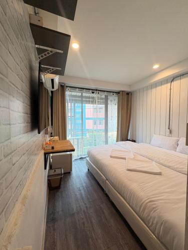 una camera da letto con un letto, una scrivania e una finestra di 333 MiNi House a Chiang Mai
