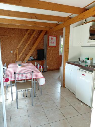 une cuisine et une salle à manger avec une table et des chaises dans l'établissement Le Belchard, à La Chapelle-Bayvel