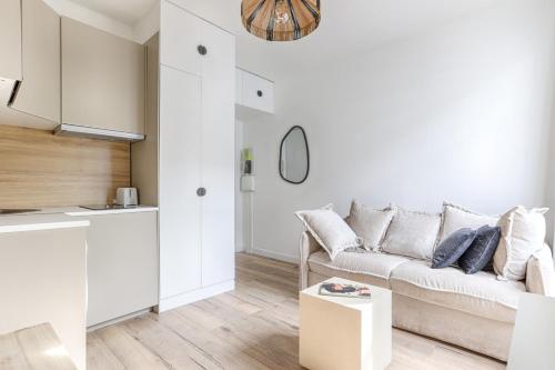 un salon blanc avec un canapé et une table dans l'établissement Cozy Studio on Mobility Lease, à Boulogne-Billancourt