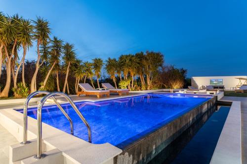 a swimming pool with palm trees in the background at Villa Irene Royale - Pool - Sea View - Free Cruise in Tigaki
