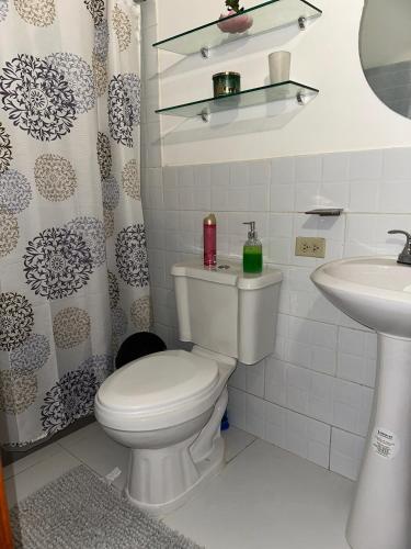 une salle de bains avec toilettes et lavabo dans l'établissement Deluxe, à Catacamas